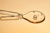 Close-up of a spoon with liquid on a beige background