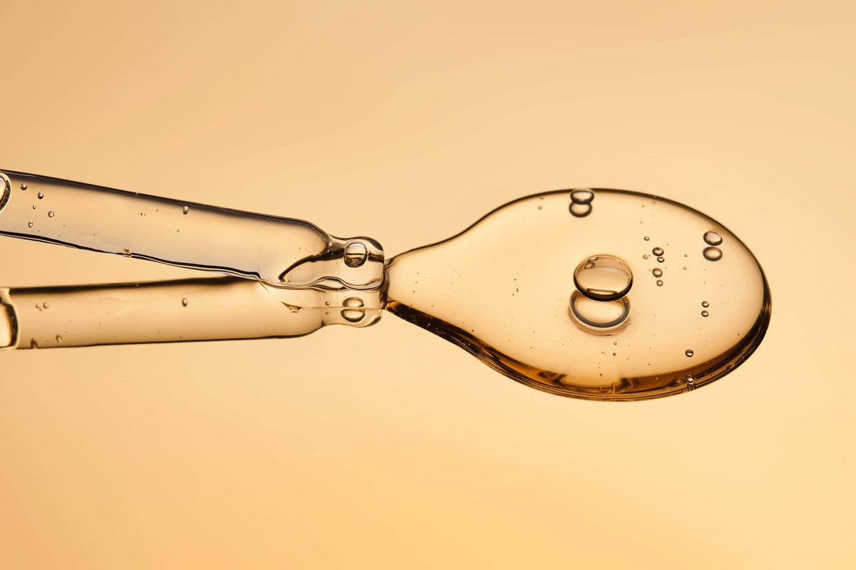Close-up of a spoon with liquid on a beige background