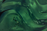 Close-up of green liquid with droplets and reflections