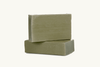 Two stacked green soap bars on a white background