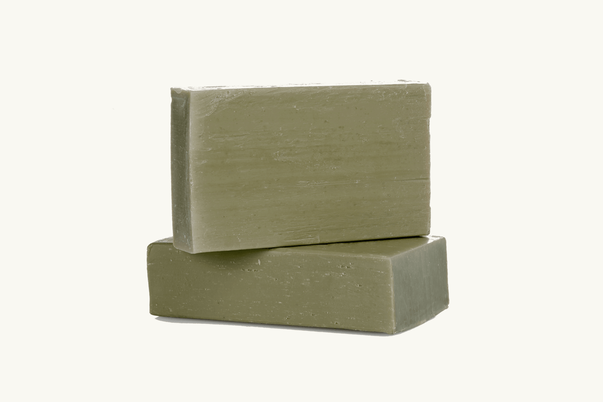 Two stacked green soap bars on a white background
