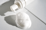 Foam product with a pump bottle on a gray surface