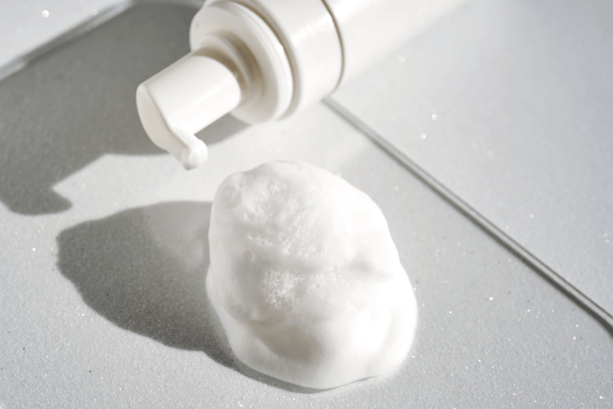Foam product with a pump bottle on a gray surface