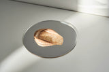 Metallic object on a reflective surface with a light source casting shadows